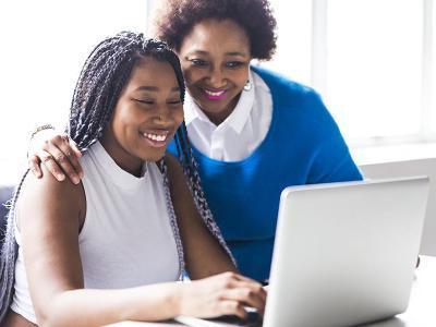 Mom and student look at computer.